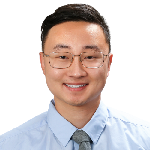 Smiling man wearing glasses, a light blue dress shirt, and a gray tie (head-and-shoulders portrait).