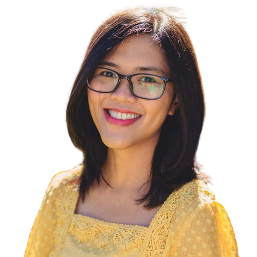 Smiling woman with glasses facing the camera wearing a yellow lace top